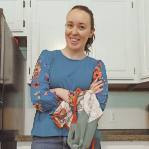 A woman holding an apron as she smiles in her kitchen