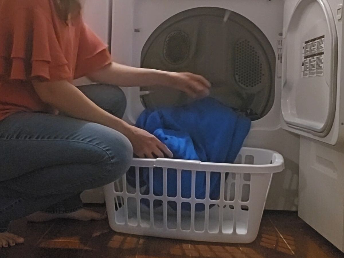 woman removing blankets from dyer