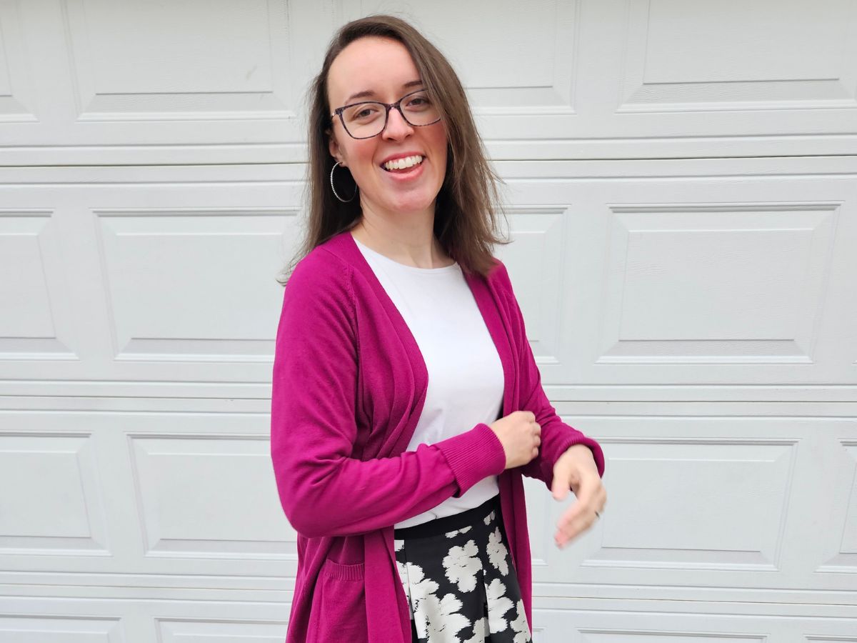 woman laughing in winter white and gem colored cardigan