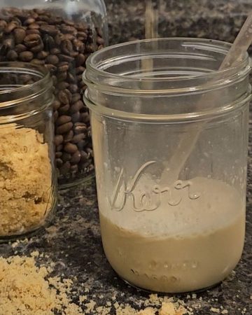 brown sugar latte with brown sugar and whole coffee beans in background
