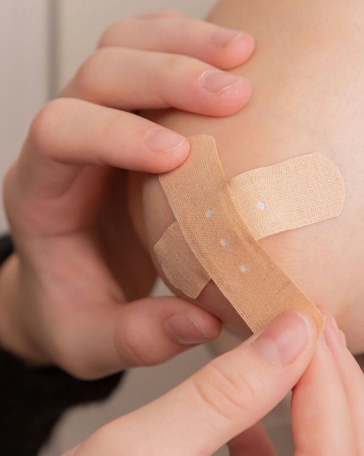 putting a bandaid on an elbow
