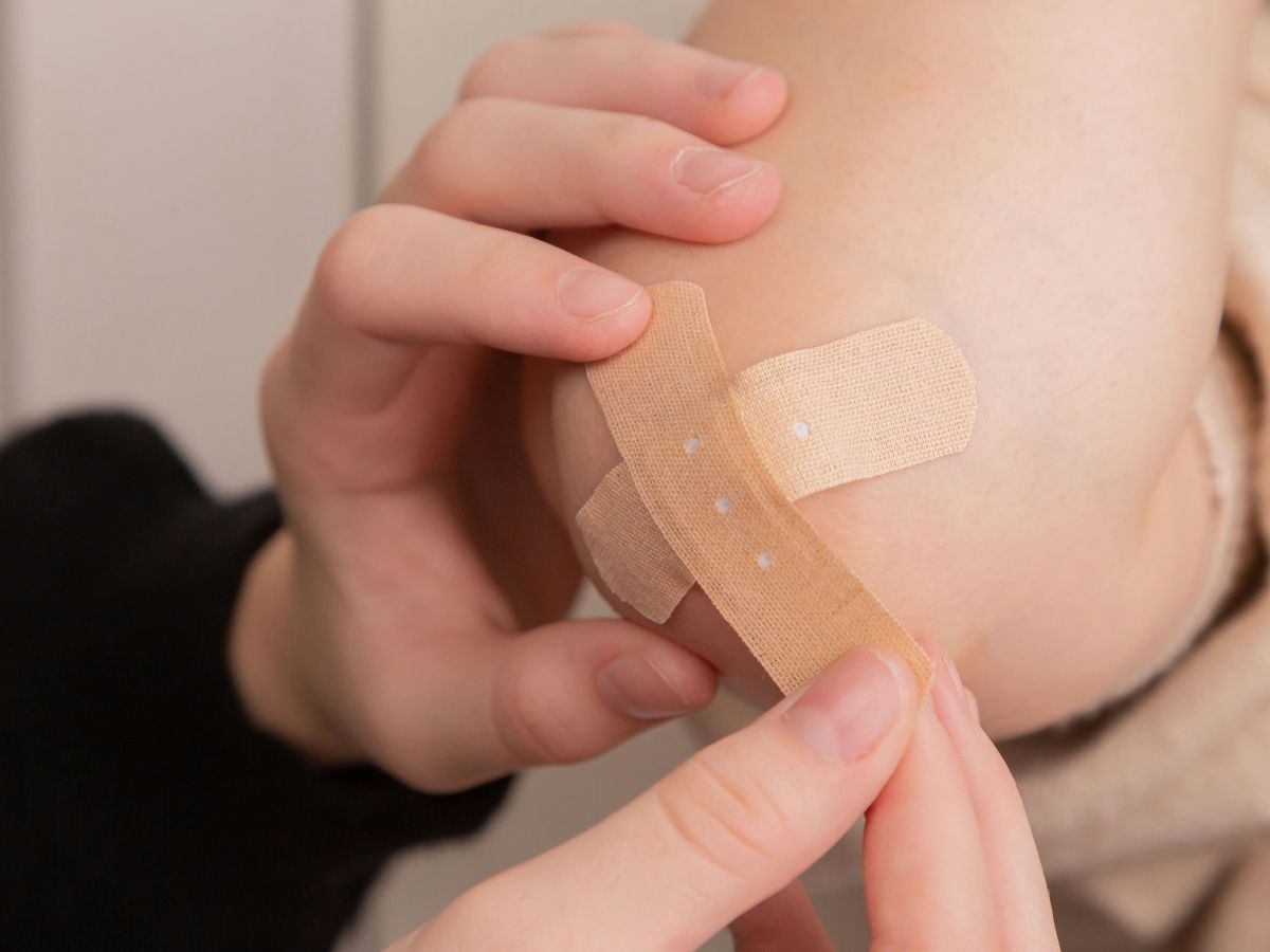 putting a bandaid on an elbow